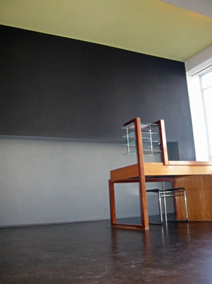 Büro van Walter Gropius, unner den lecht-geelen Bäöhn sett sich dei blaw-griese Wand keuhl af